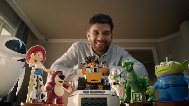 A man views Robosen MINI Robots, with WALL·E center stage and Toy Story characters in the background